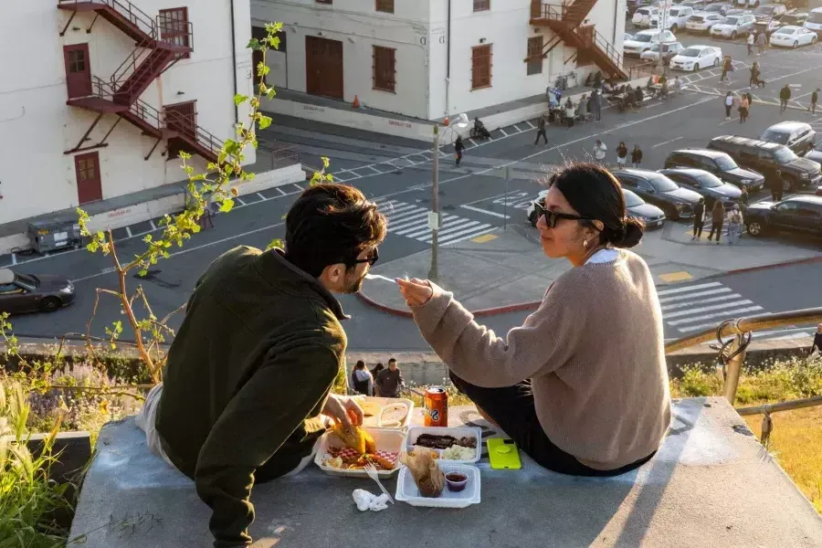 这对夫妇在贝博体彩app梅森堡中心的户外用餐。. 女人给她的同伴一个品酒会。.