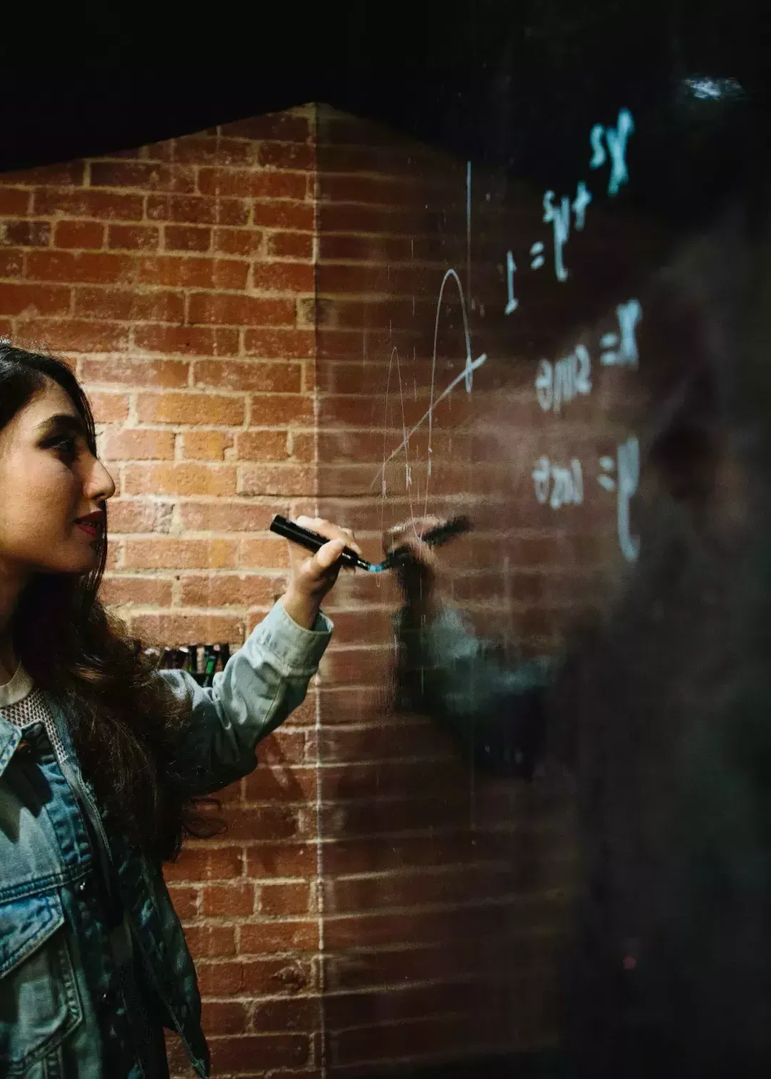 Ayman Nadeem writing on a whiteboard.